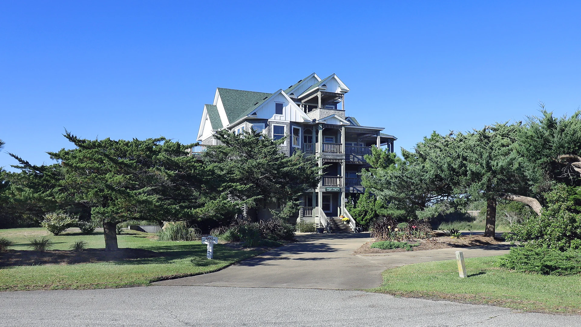 Trees line the front yard of this vacation rental available in 2024 in Hatteras